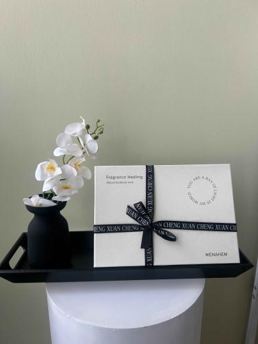 صينية خشبية مع شمعة ودفيوزر وفازة أوركيد صناعي