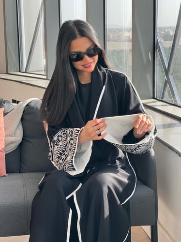 عباية بقماش راما أسود فاحم وتطريز أبيض بالأكمام