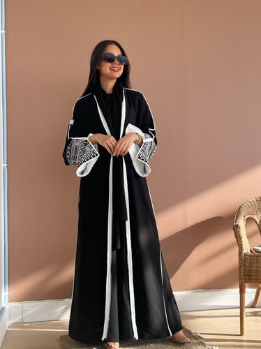 عباية بقماش راما أسود فاحم وتطريز أبيض بالأكمام