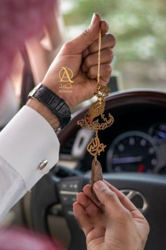 تعليقة سياره يد ماسكه ورده بكسرة العود بالاسم