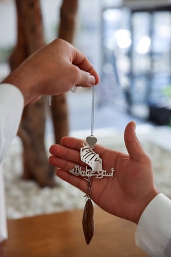 تعليقة كسرة العود بشكل يد فوقها قلب