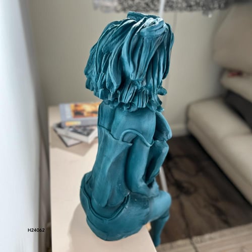 تمثال لشخصية انثوية حالمة تجلس بوضعية تأملية على ح...