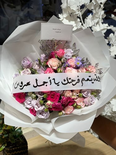 باقة ورد مع شريط عبارة