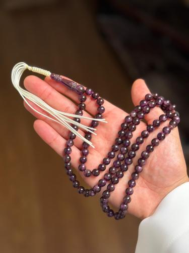 A round prayer bead with lavender color.
