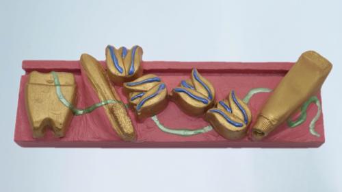 The paste and brush are on a rectangular base decorated with golden roses.