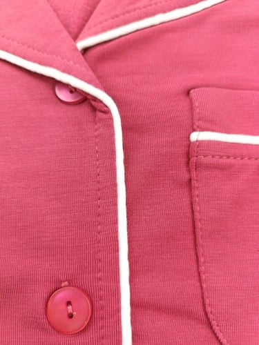 بجامه نسائي لون احمر فاتح بحواف بيضاء وأزرار