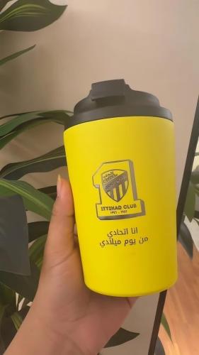 كوب قهوة فاخر بشعار نادي الاتحاد – تصميم أنيق لعشا...