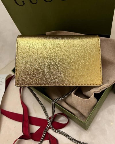 Gucci women's Dionysus clutch in a modern golden c...