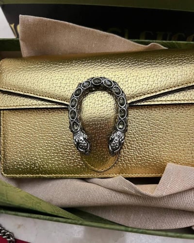 Gucci women's Dionysus clutch in a modern golden c...