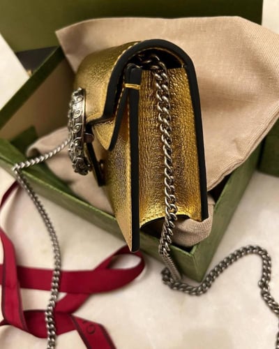 Gucci women's Dionysus clutch in a modern golden c...