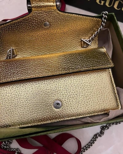 Gucci women's Dionysus clutch in a modern golden c...