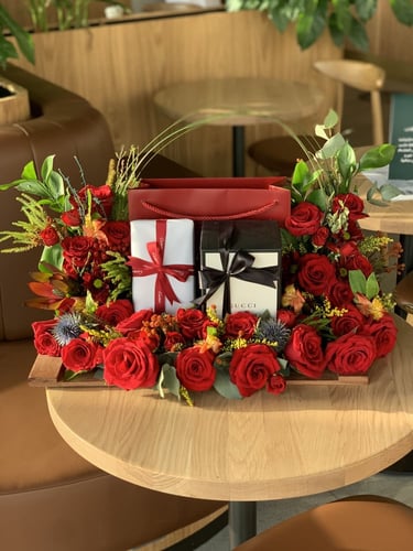 تنسيق مجموعة هدايا على قاعدة خشبية مع الورد