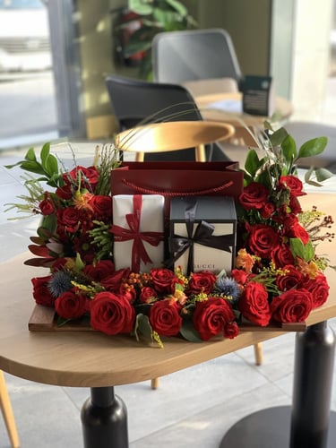 تنسيق مجموعة هدايا على قاعدة خشبية مع الورد