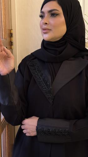 عباية سوداء سادة مزينه بتفته من الرقبة ومن الاكمام...