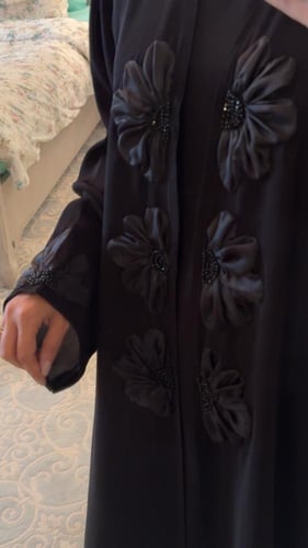 عباية سوداء مزينه بالورود وفيها قطعه داخليه مثل ال...