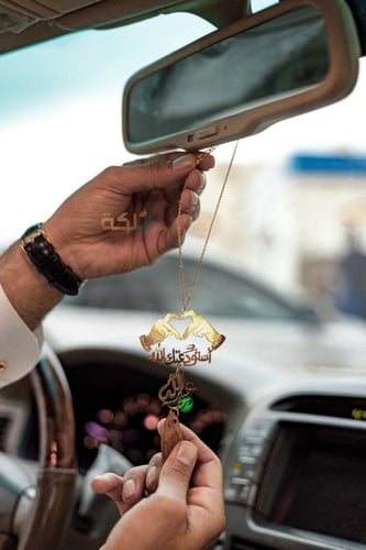 تعليقة عود ذهبية بيدين بشكل قلب