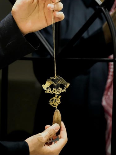 تعليقة عود ذهبية بيدين بشكل قلب