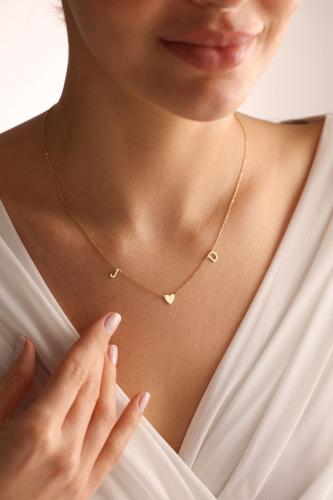 A soft necklace with two letters and a heart