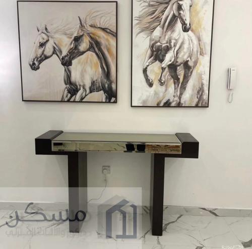 طاولة كونسول خشبيه داكنة مع سطح زجاجي عاكس