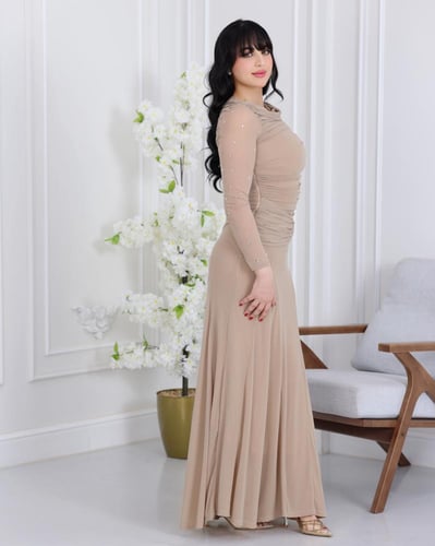فستان بلون بيج راقٍ بتصميم أنثوي وانسيابي