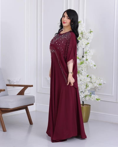 فستان عنابي بتصميم طبقات وتطريز كريستالي متدلٍ