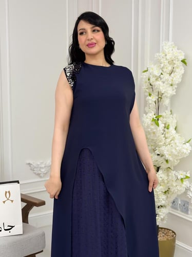 فستان كحلي بطبقات انسيابية وتفاصيل لامعة