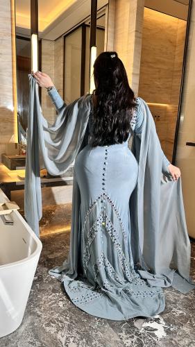 An elegant Tiffany-colored dress with a flowing design and shiny embroidery, with sleeves that add a touch of sophistication and a...