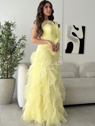 فستان سهرة أصفر مزيّن بطبقات ناعمة وفتحة أمامية