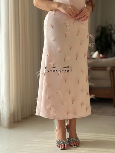 فستان وردي فاتح بتفاصيل ريش ناعمة