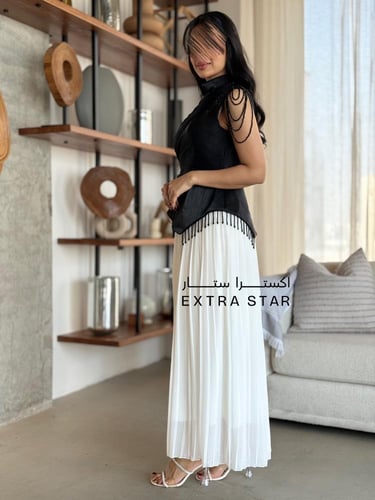 فستان أسود وأبيض بتفاصيل علوية أنيقة وتنورة بليسيه...