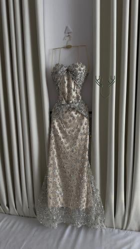 فستان سهرة مطرز بالفضي بتصميم فاخر ولمعة راقية