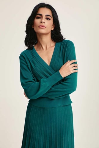 بلوزة محبوكة لامعة بياقة لف