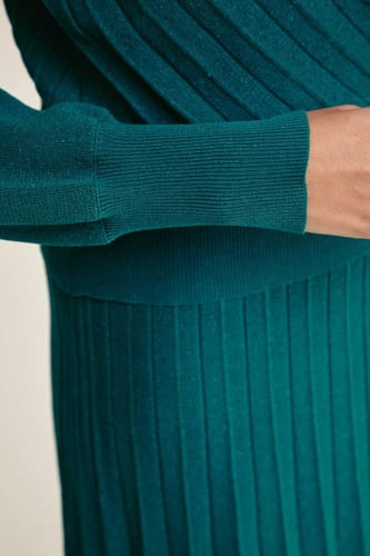 بلوزة محبوكة لامعة بياقة لف