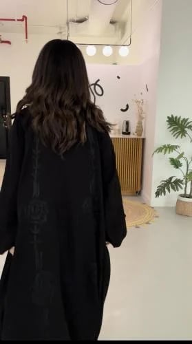 A loose abaya with embroidery on the back and slee...