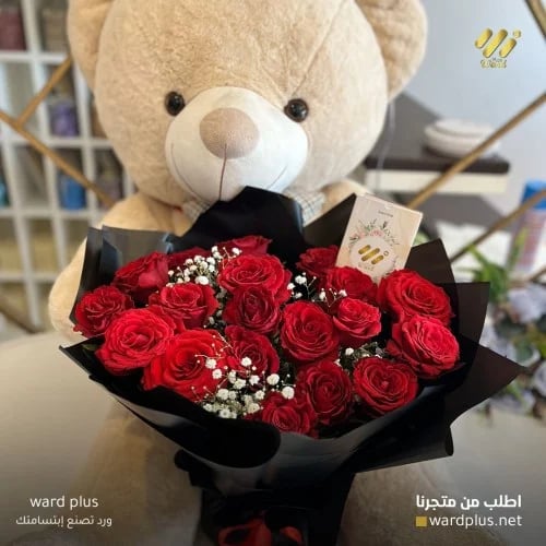 A bouquet of flowers with a teddy bear