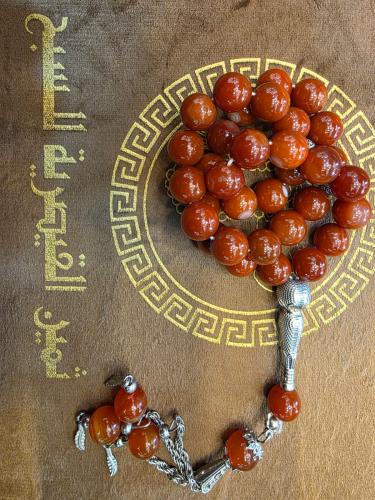 A prayer bead made of kidney-colored agate