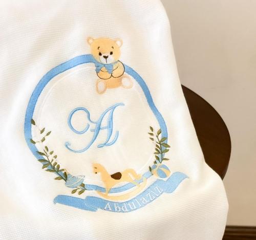 A embroidered blanket with two designs (bear and h...