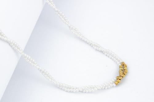 عقد لؤلؤ مع ذهب بتصميم مبروم