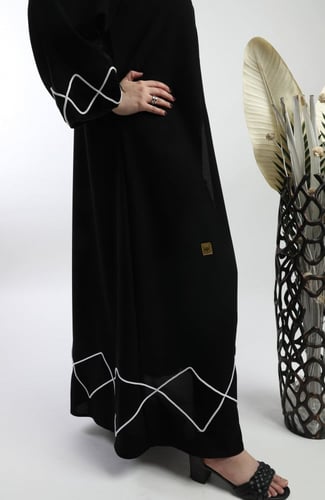 عباية سوداء مزينة بتفاصيل غير تقليدية من القيطان ا...