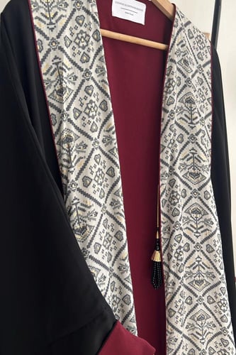 عباية باللون الأسود والعنابي