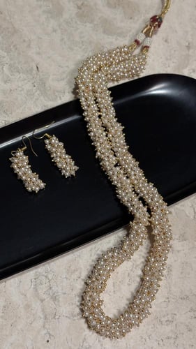 عقد وحلق مزين باللؤلؤ