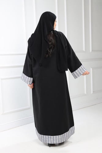 عباية شتوية منسوجة من قماش الجوخ الأسود مع طرحتها.