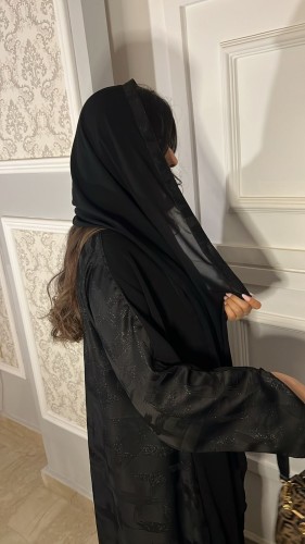 A-line abaya, royal black fabric, half, and from the back, half fabric wall with a headscarf with a tail.