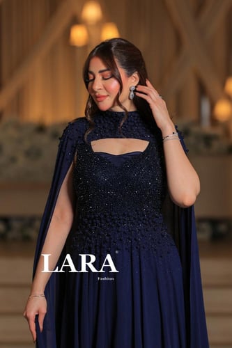 فستان فاخر بلون كحلي، يتميز بتطريز بارز ولامع يغطي...