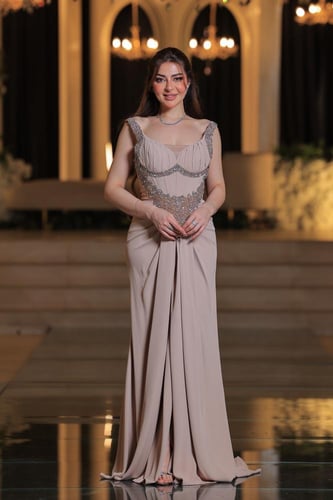 فستان بتصميم سهرة راقٍ بلون بيج ناعم، يتميز بقصة ع...