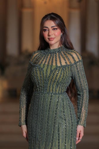 فستان أنيق وفاخر، يتميز بتصميم طويل بلون زيتي مائل...