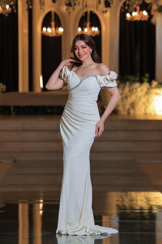 فستان أنيق وفخم، يتميز بتصميم طويل بلون أبيض ناصع...