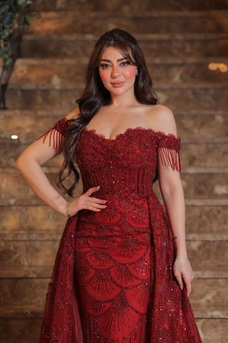 فستان سهرة فخم بلون أحمر براق، يتميز بتصميم أوف شو...