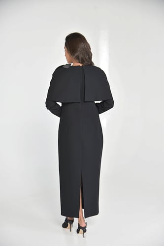 فستان أسود أنيق بتفصيل كاب فاخر يغطي الأكتاف