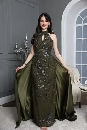 An olive evening dress with luxurious embroidery and a train